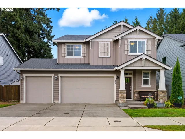 a front view of a house with a garden and trees