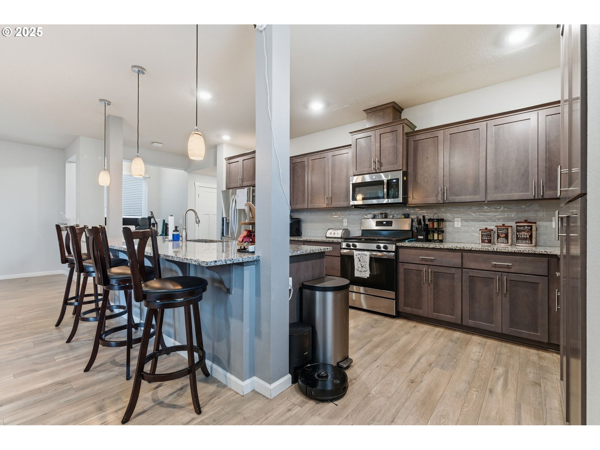 476 Southwest 15th Avenue Canby, OR 97013 - Photo 18 of 43 a kitchen with stainless steel appliances kitchen island granite countertop a table chairs microwave and sink