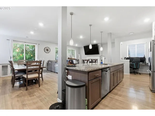 a kitchen with stainless steel appliances granite countertop a sink a stove top oven a counter space and cabinets