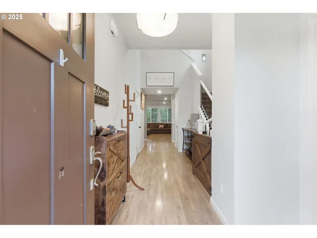 a view of hallway with wooden floor and stairs