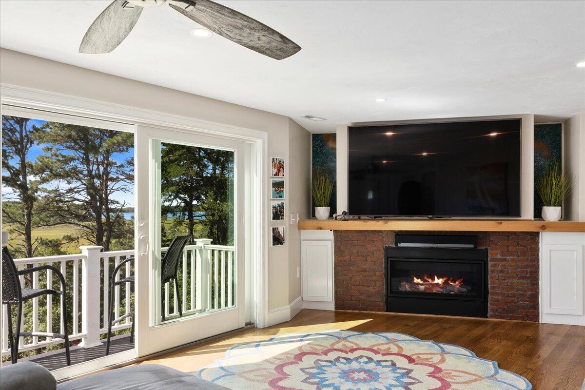 31 Amy Brown Road Mashpee, MA 02649 - Photo 35 of 95 a living room with a fireplace and a floor to ceiling window