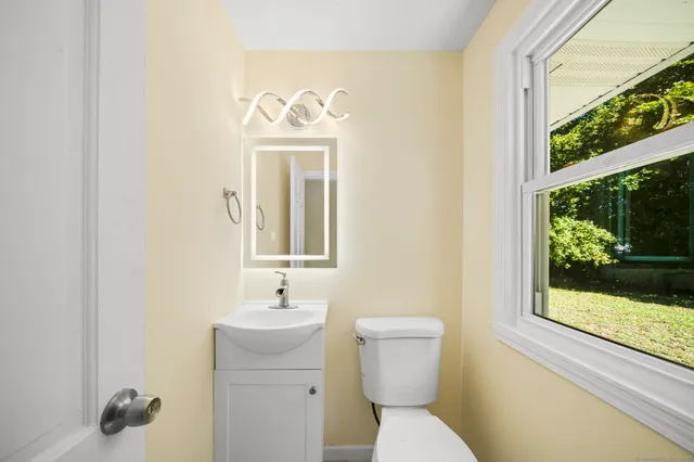 a bathroom with a toilet sink and mirror