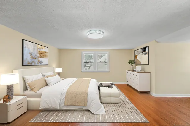 a bedroom with a bed and painting on the wall