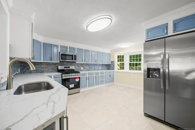 a kitchen with stainless steel appliances granite countertop a refrigerator sink and stove