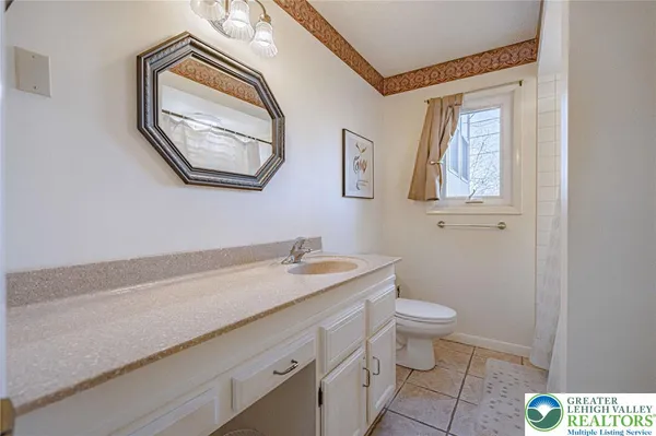 a bathroom with a granite countertop toilet a sink and mirror