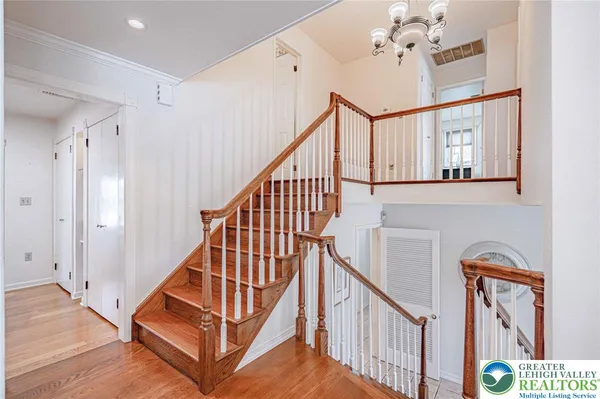 a view of staircase with railing and a chandelier