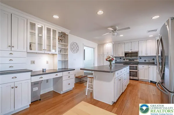 a kitchen with stainless steel appliances granite countertop a stove cabinets and wooden floor