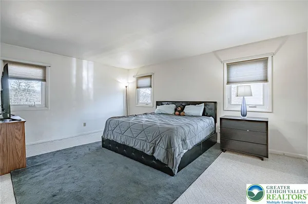 a bedroom with a large bed and a flat tv screen