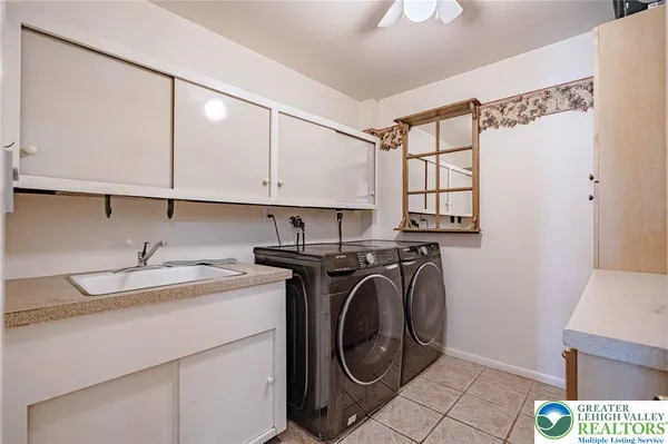 a utility room with cabinets washer and dryer