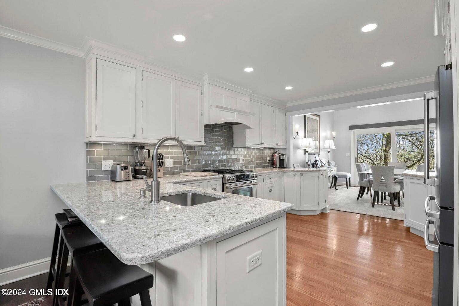 1 Old Church Road, Unit 1 Greenwich, CT 06830 - Photo 3 of 17 a kitchen with granite countertop kitchen island a table and chairs in it