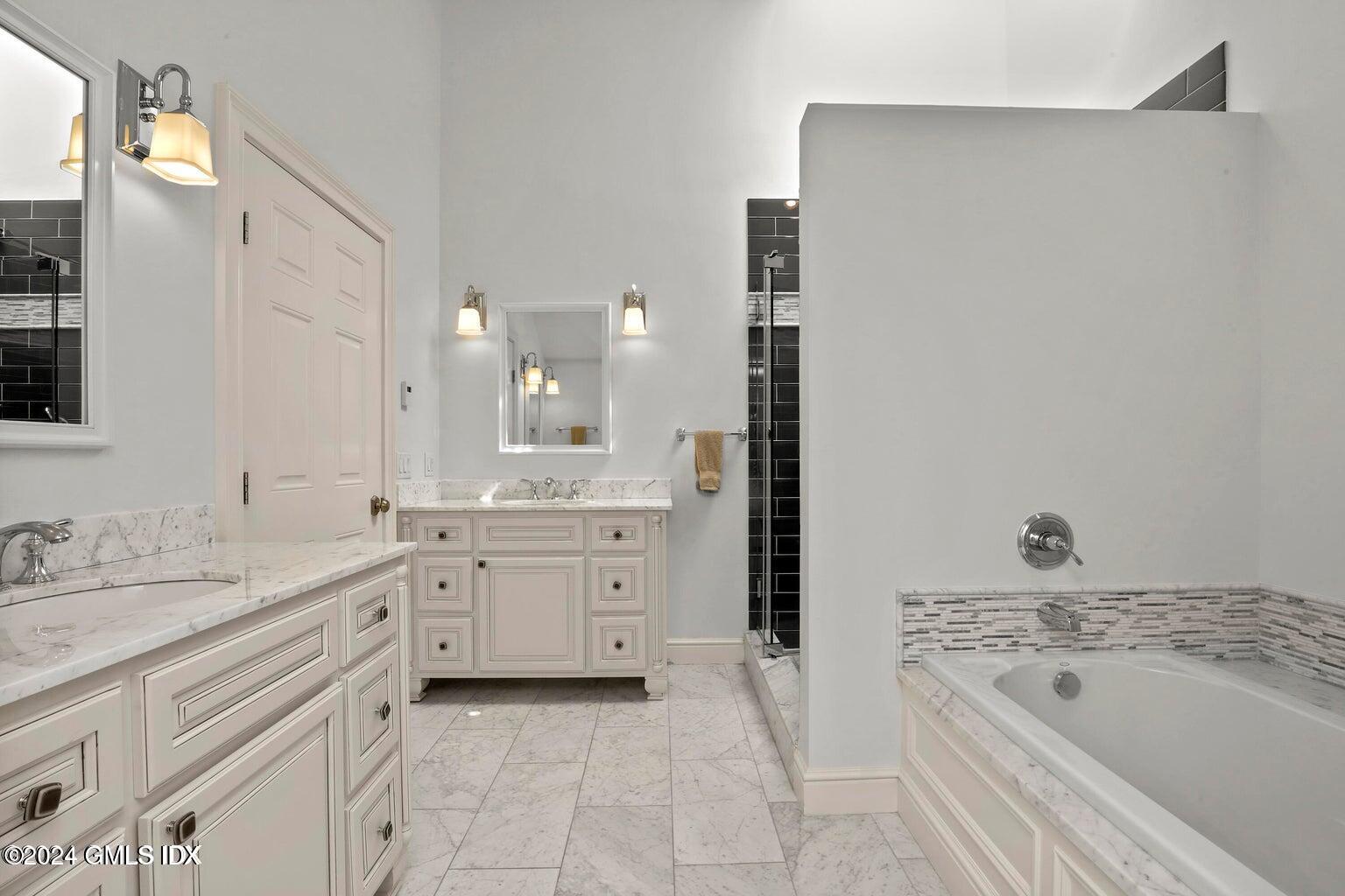 1 Old Church Road, Unit 1 Greenwich, CT 06830 - Photo 9 of 17 a spacious bathroom with a granite countertop sink a bathtub and a mirror