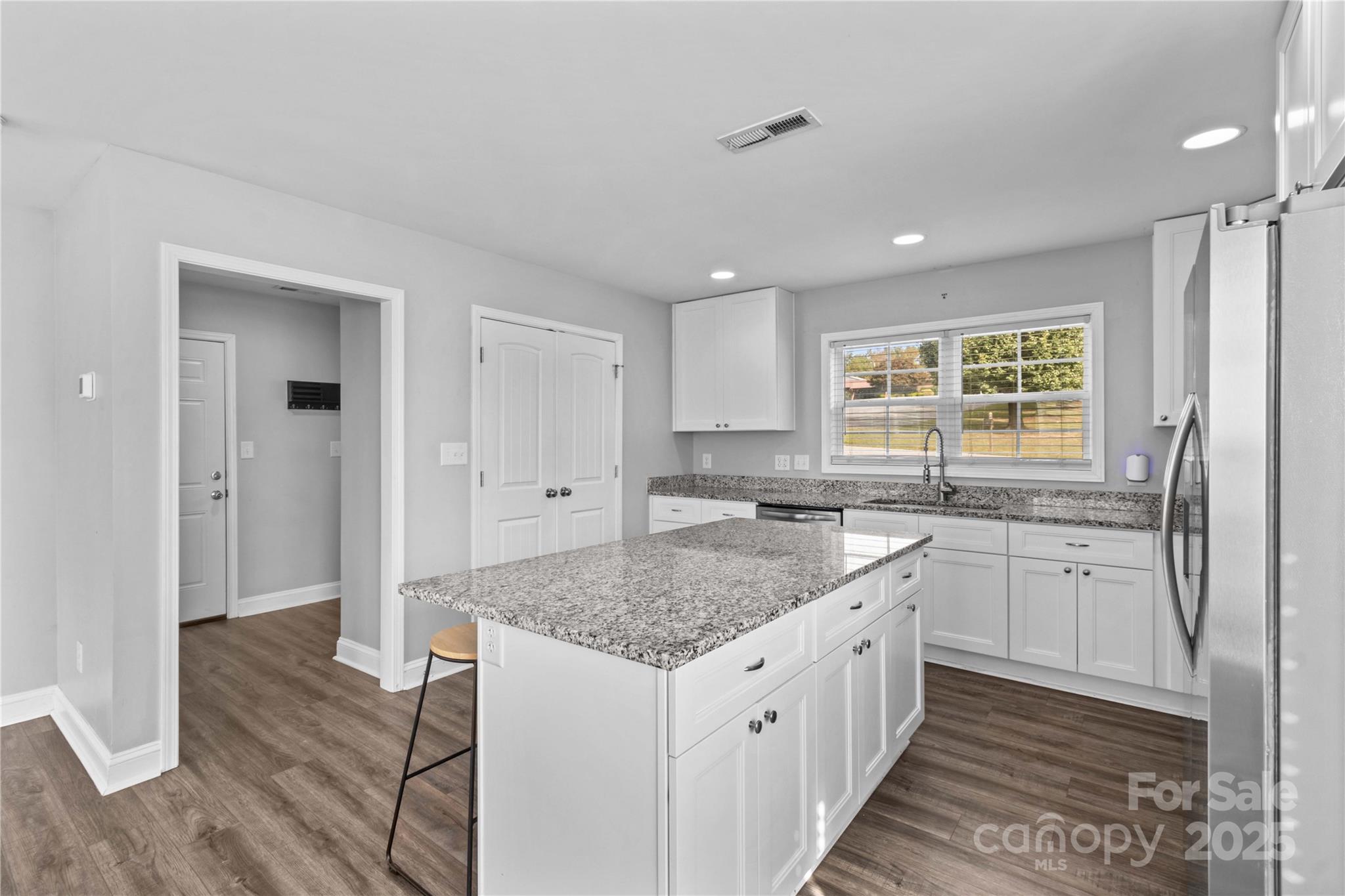 2518 Moose Road Kannapolis, NC 28083 - Photo 17 of 47 a kitchen with granite countertop kitchen island wooden floors granite counter tops and white appliances