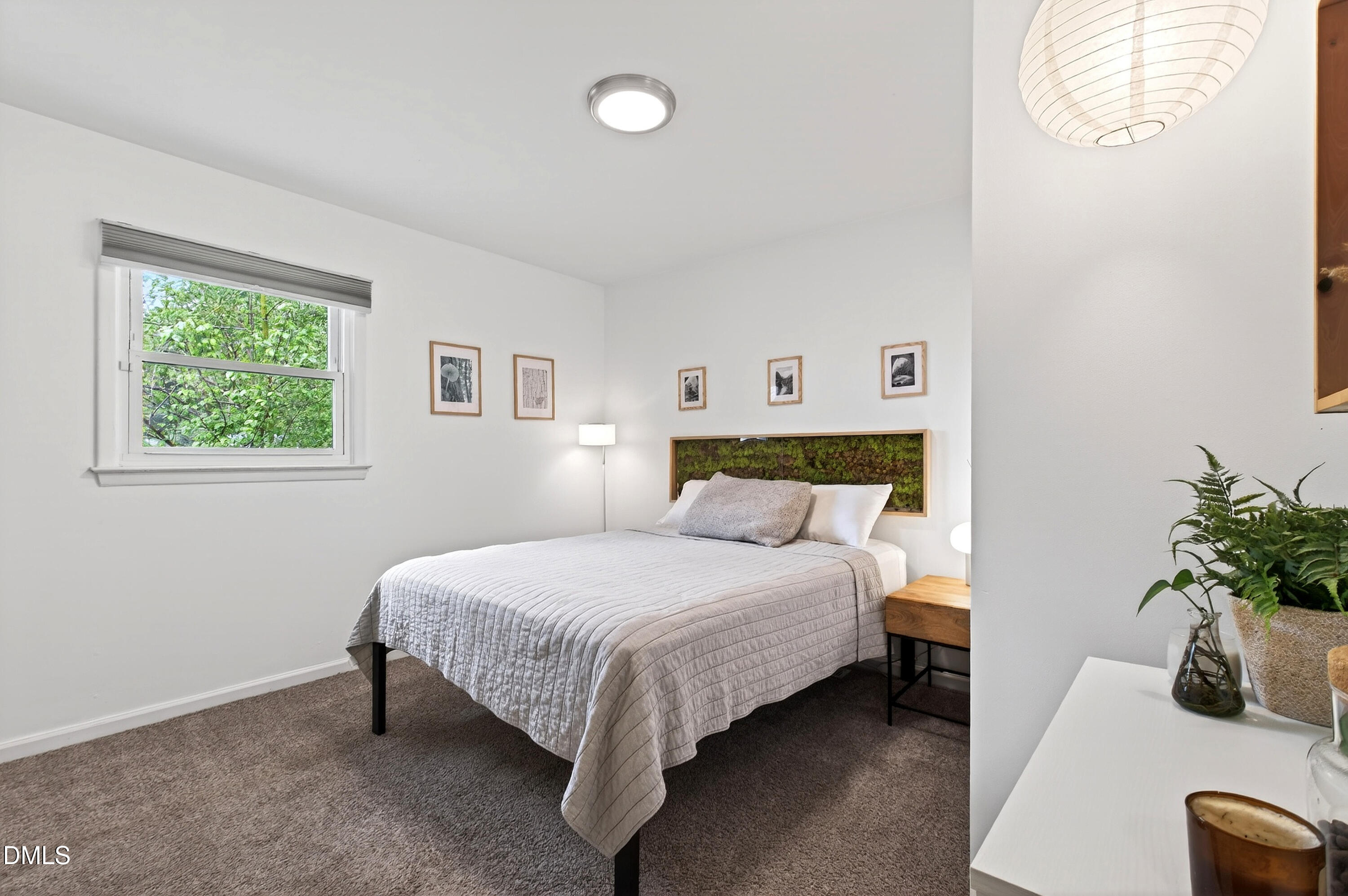 917 Carlisle Street Raleigh, NC 27610 - Photo 18 of 33 a bedroom with a bed lamp and a potted plant
