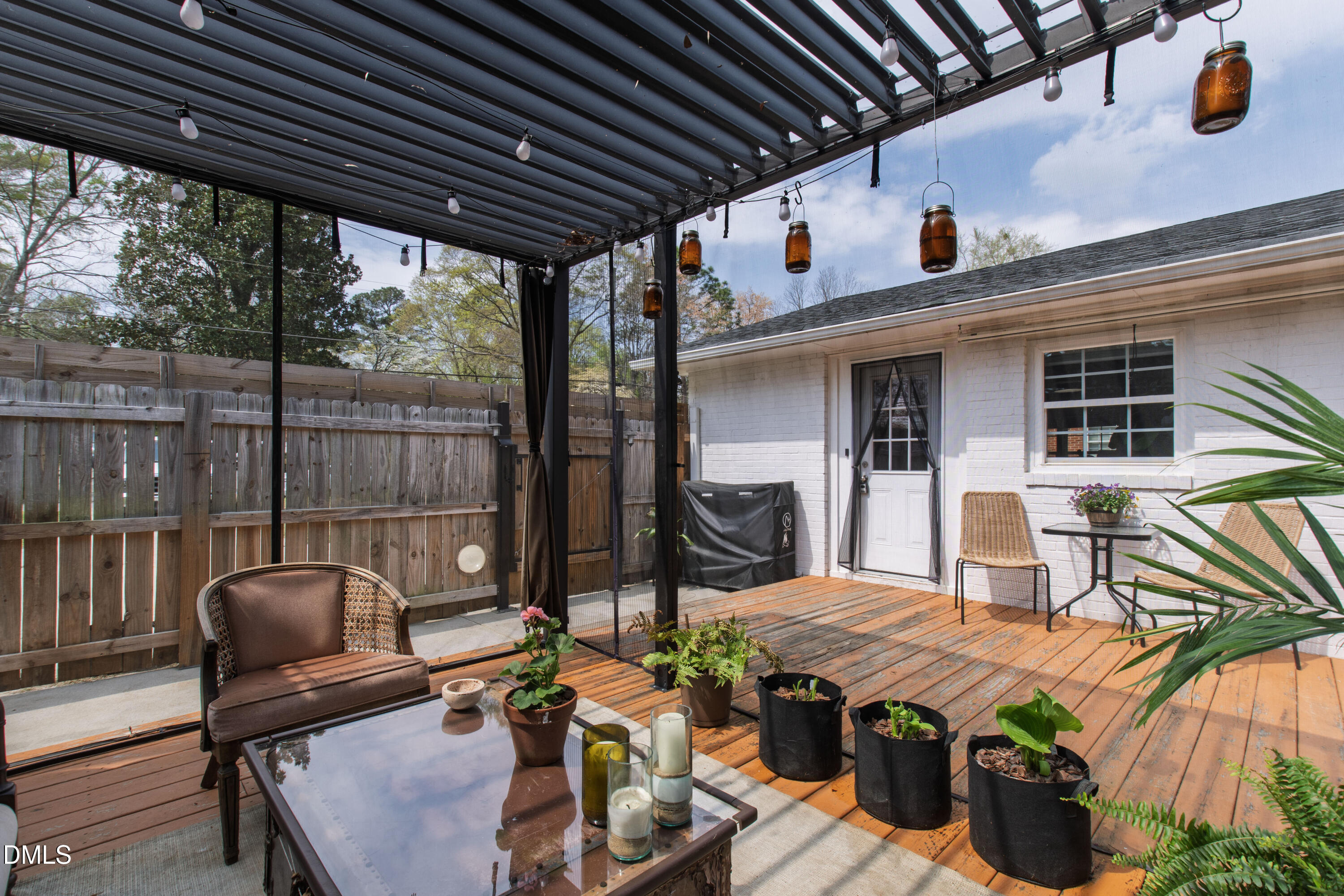 917 Carlisle Street Raleigh, NC 27610 - Photo 28 of 33 a view of a patio with table and chairs potted plants with wooden floor and fence