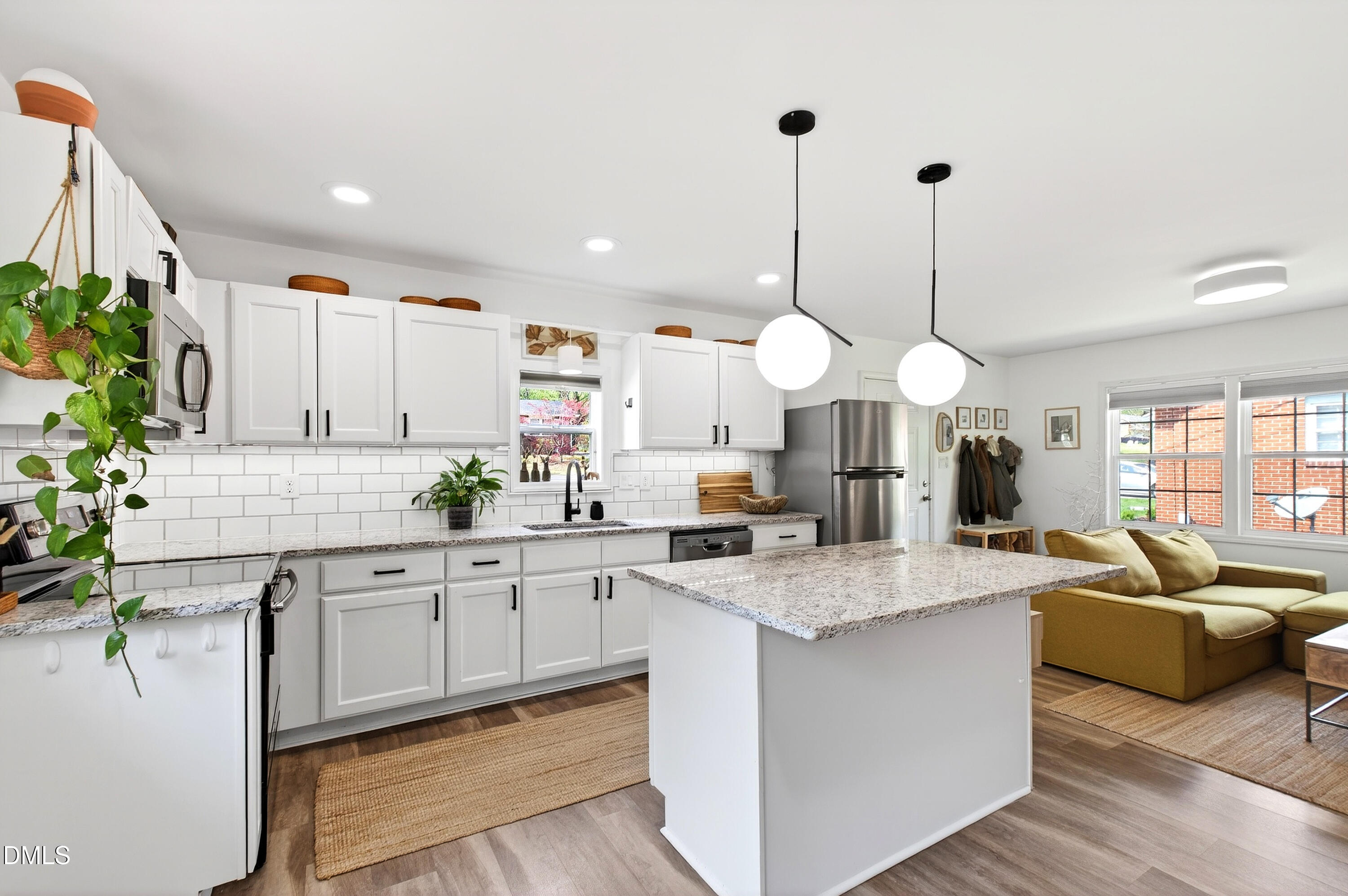 917 Carlisle Street Raleigh, NC 27610 - Photo 4 of 33 a large kitchen with kitchen island granite countertop a sink a stove and a wooden floors