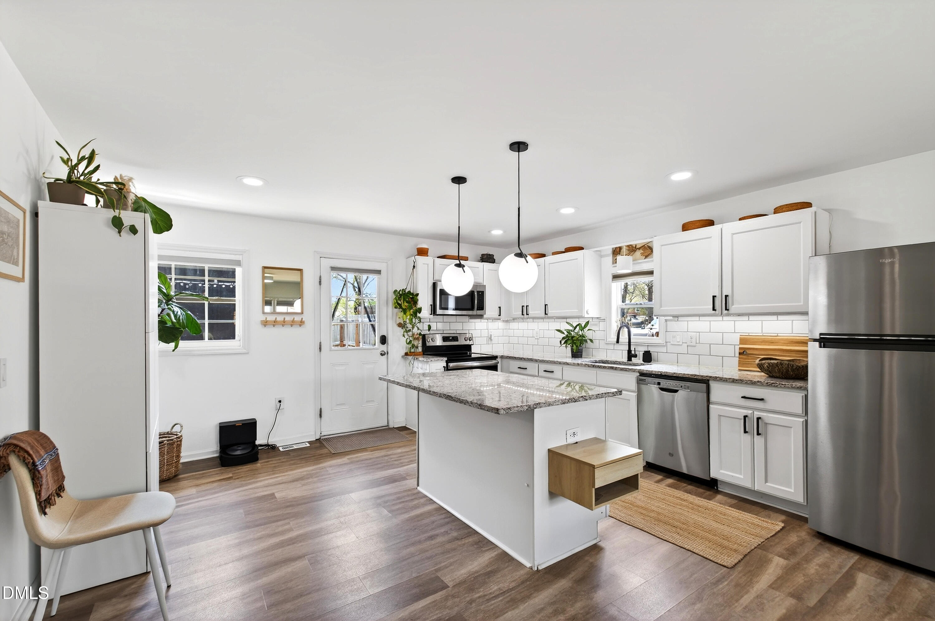 917 Carlisle Street Raleigh, NC 27610 - Photo 5 of 33 a kitchen with white cabinets and stainless steel appliances