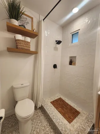 a bathroom with a toilet and a shower