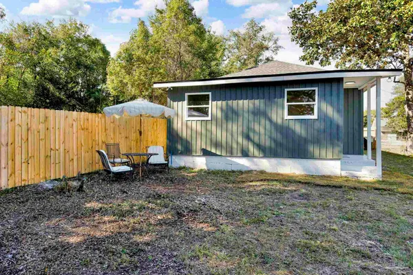 a view of a house with backyard and sitting area