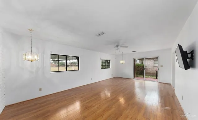 a view of a big room with wooden floor and windows