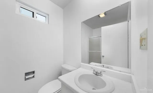 a bathroom with a sink mirror and toilet