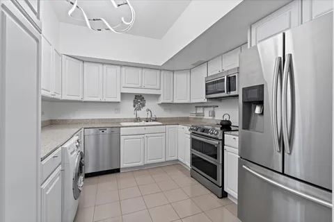 a kitchen with stainless steel appliances granite countertop a refrigerator sink and stove