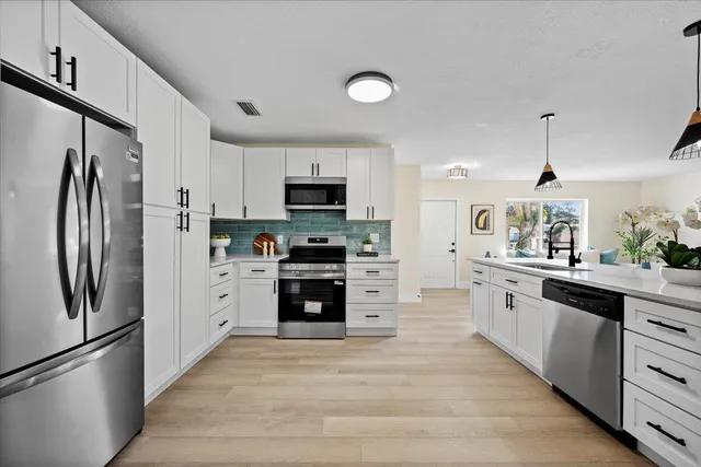 a living room with furniture kitchen view and a large window