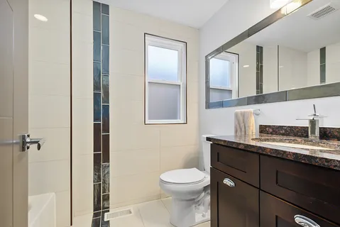 a bathroom with a toilet a sink and mirror