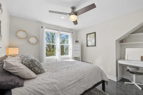 a bedroom with a bed cabinets and window