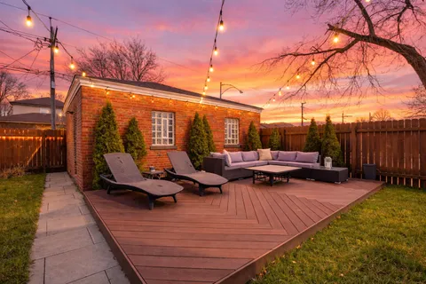 a backyard of a house with barbeque oven table and chairs