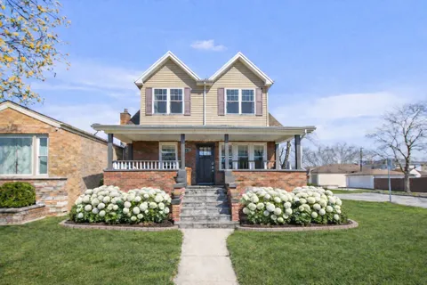 a front view of a house with a yard and potted plants