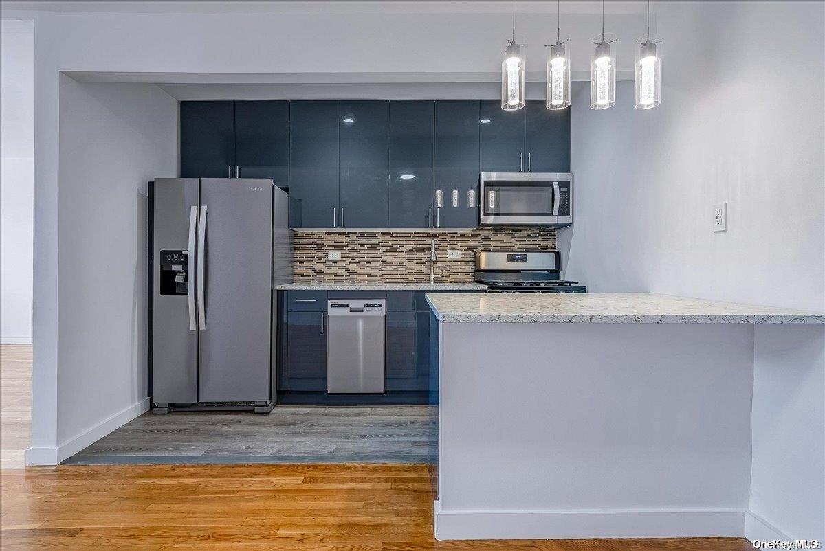 175-45 88th Avenue, Unit 7B Queens, NY 11432 - Photo 1 of 1 a kitchen with stainless steel appliances granite countertop a refrigerator and a sink