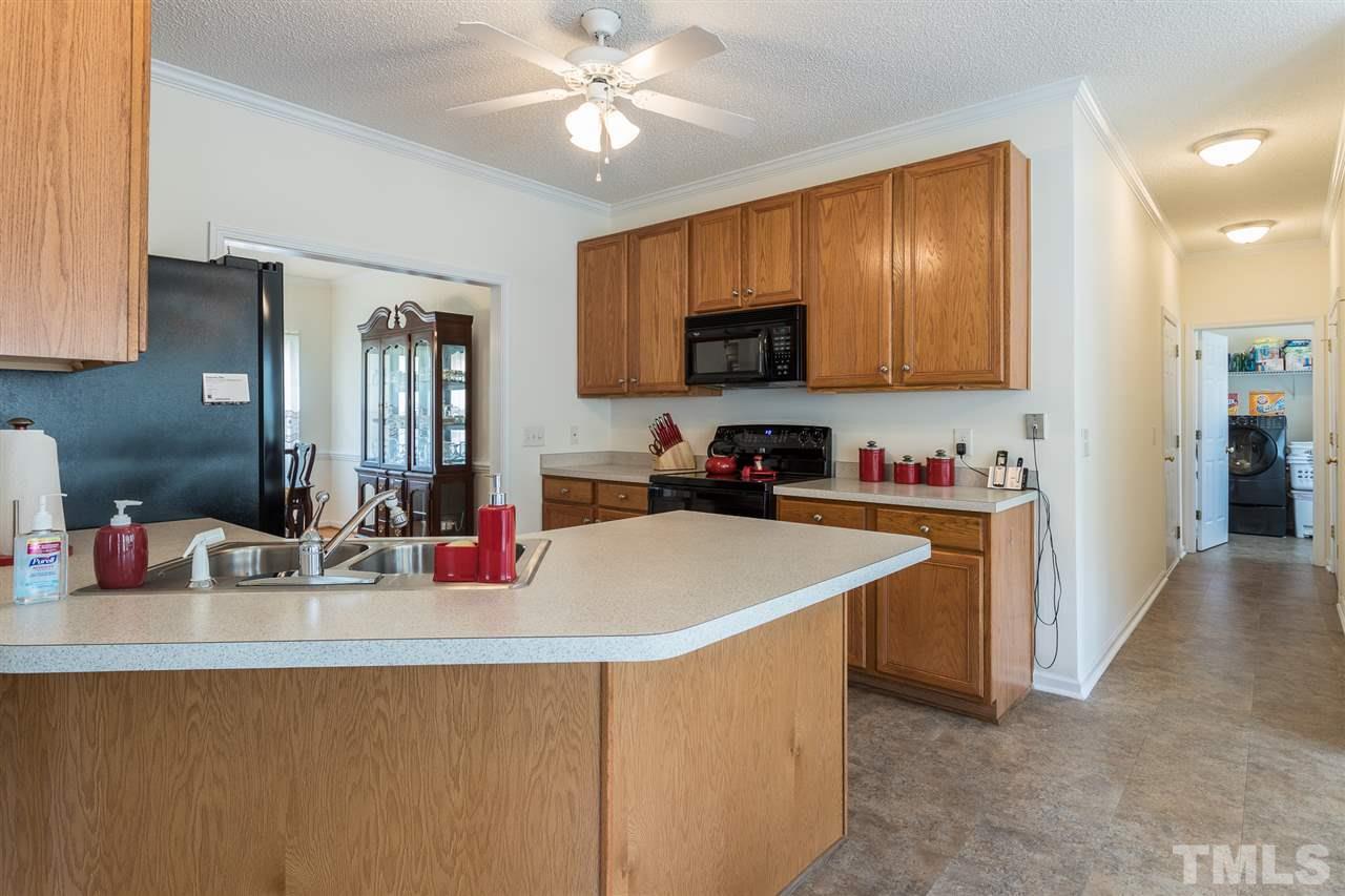 8509 Ridgebury Road Raleigh, NC 27603 - Photo 11 of 30 a kitchen with a sink stove top oven and cabinets