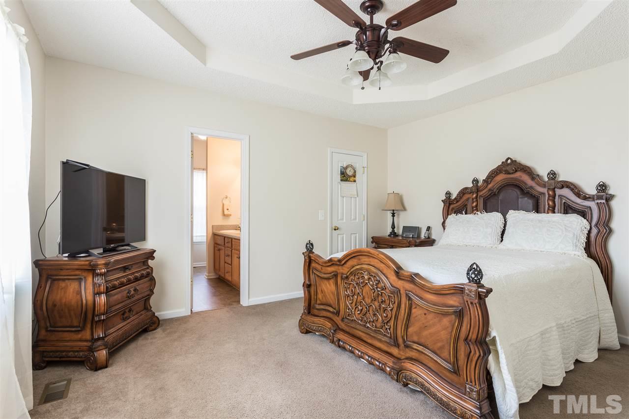 8509 Ridgebury Road Raleigh, NC 27603 - Photo 15 of 30 a bedroom with furniture and a flat screen tv