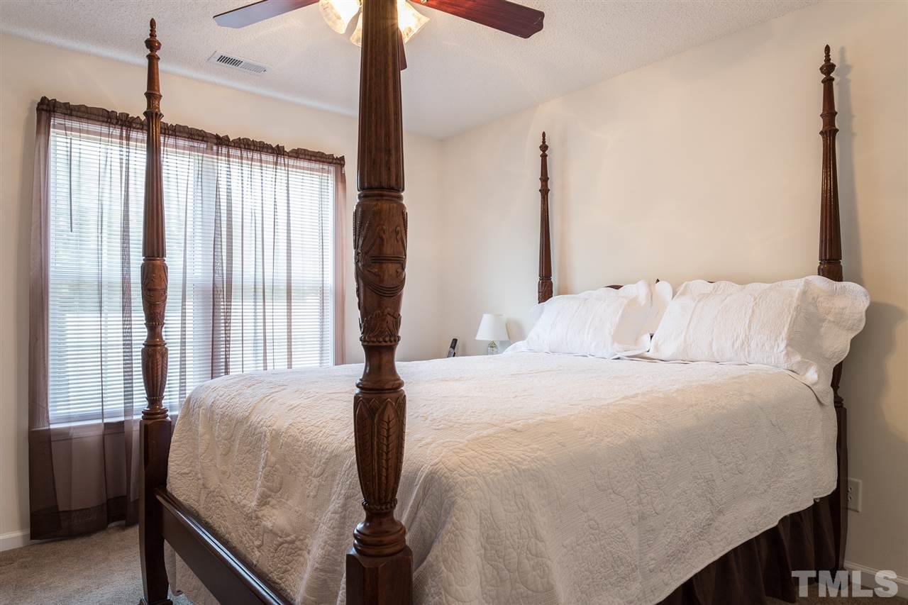 8509 Ridgebury Road Raleigh, NC 27603 - Photo 21 of 30 a bedroom with a bed and a chandelier