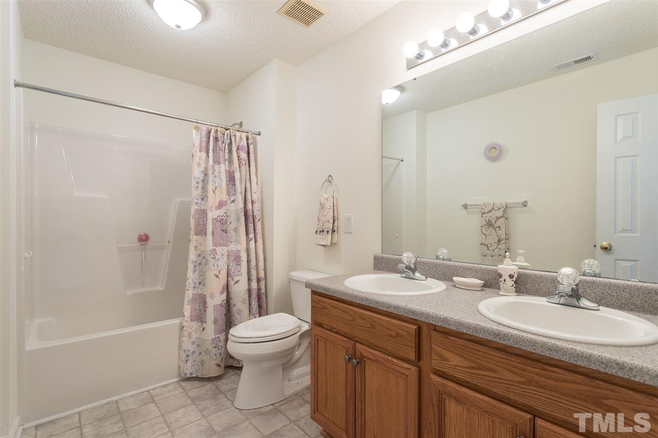 8509 Ridgebury Road Raleigh, NC 27603 - Photo 23 of 30 a bathroom with a granite countertop sink toilet and shower