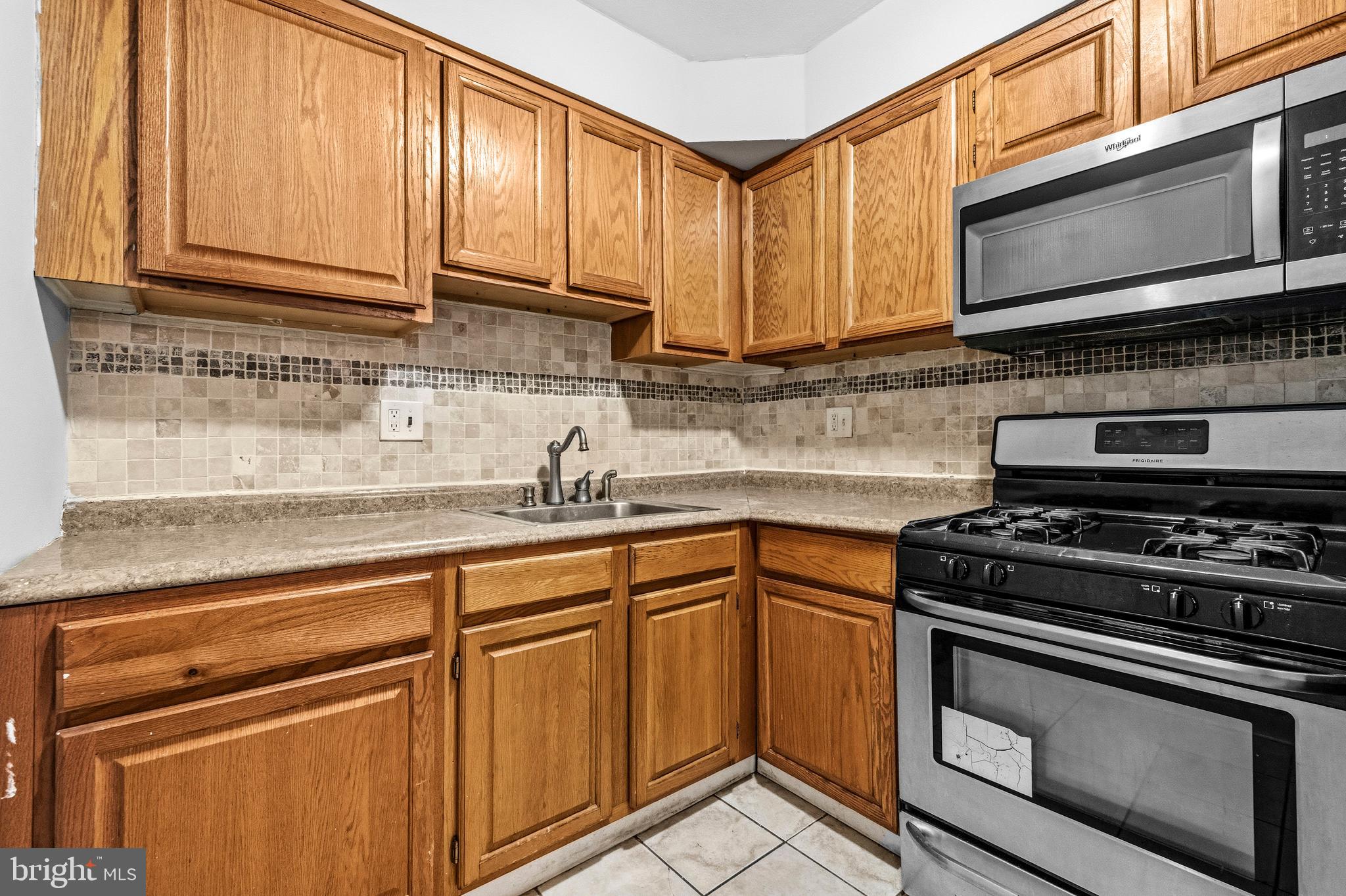1983 Addison Road South District Heights, MD 20747 - Photo 15 of 32 a kitchen with stainless steel appliances granite countertop a sink stove and microwave