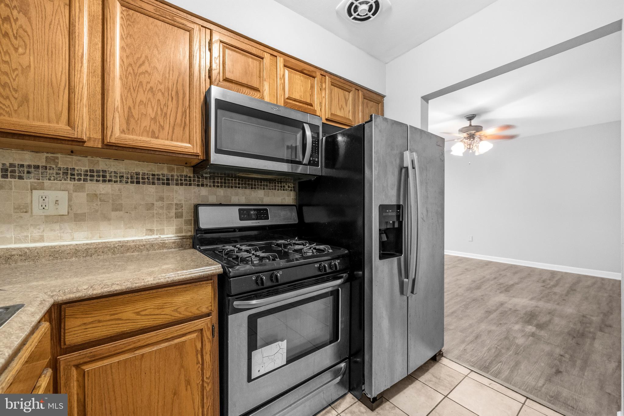 1983 Addison Road South District Heights, MD 20747 - Photo 16 of 32 a kitchen with stainless steel appliances granite countertop a stove microwave and refrigerator