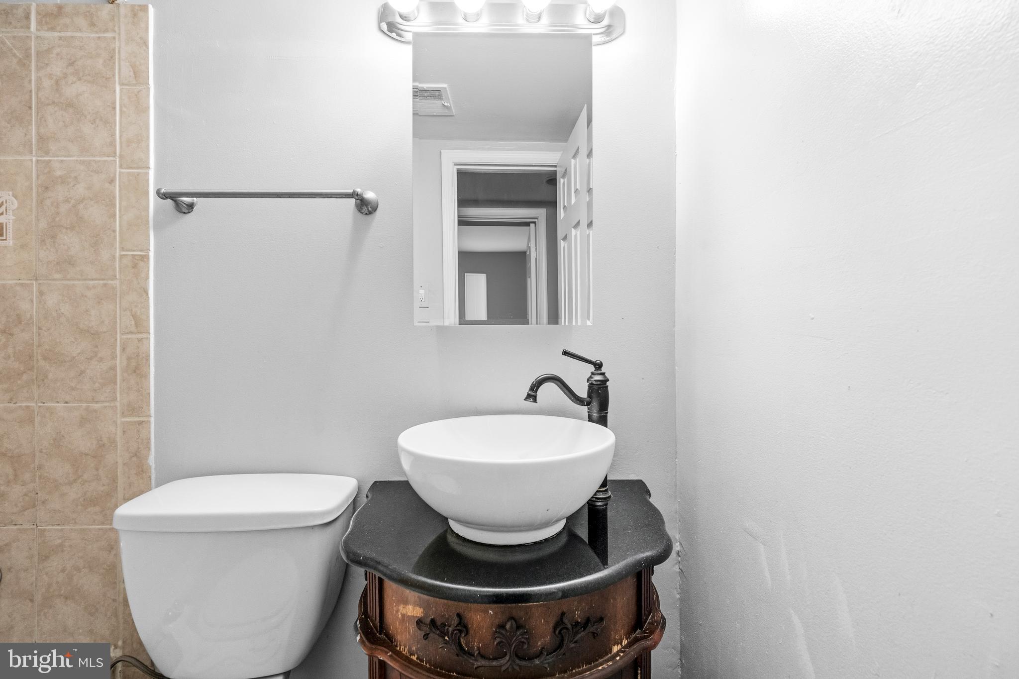 1983 Addison Road South District Heights, MD 20747 - Photo 29 of 32 a bathroom with a toilet a sink and mirror