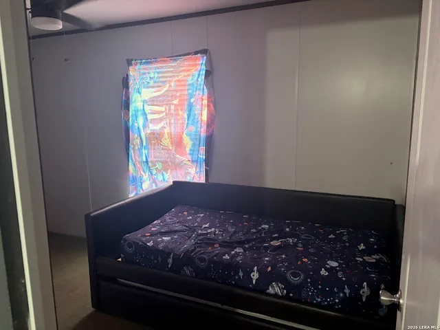 a bed sitting in a bedroom next to a window