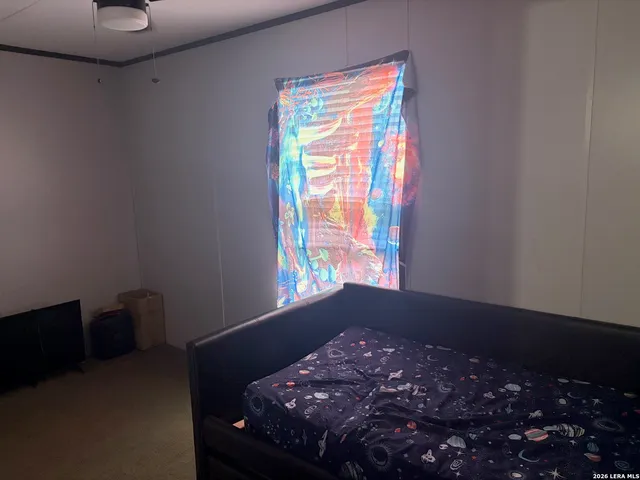 a bed sitting in a bedroom next to a window