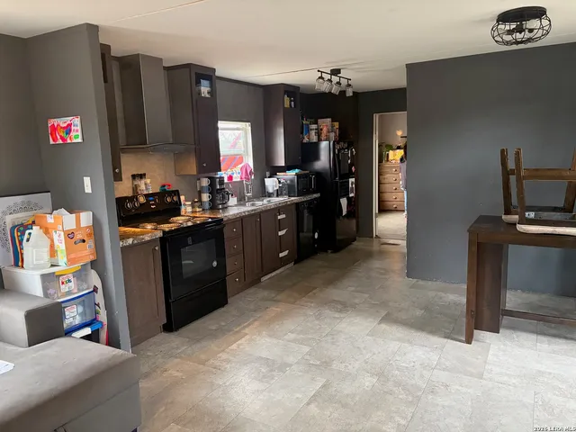 a kitchen with granite countertop a refrigerator stove and sink