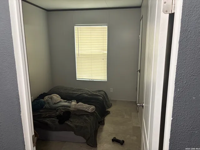 a bed sitting in a bedroom next to a window