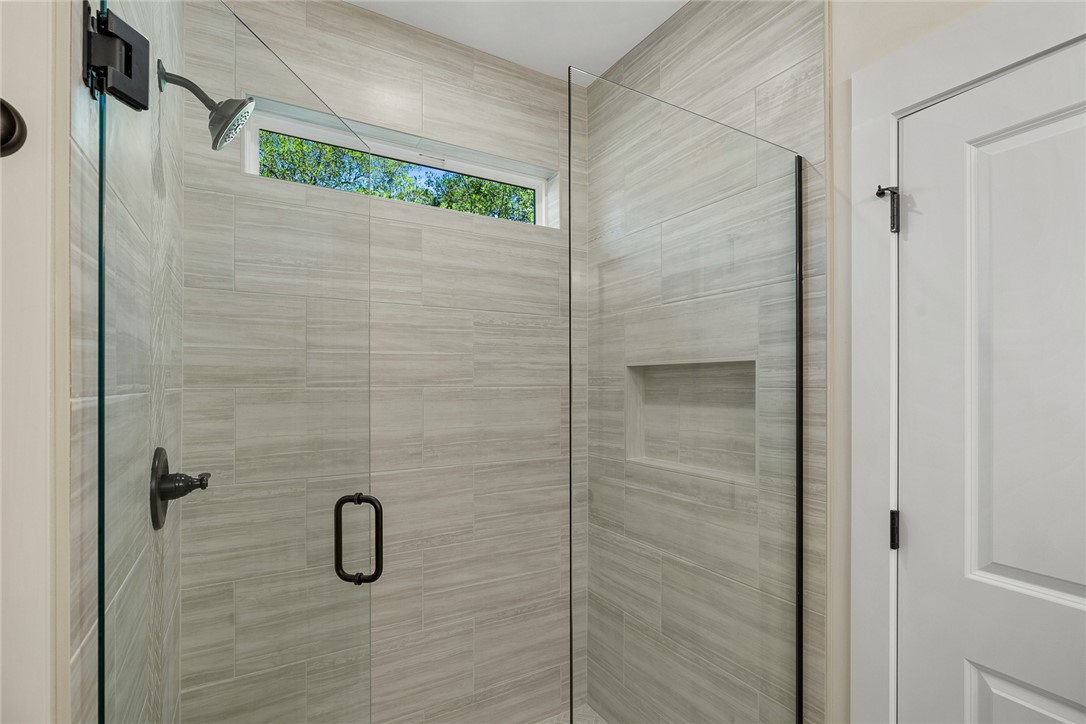 100 Garden Gate Drive Anderson, SC 29621 - Photo 24 of 43 This sleek shower features modern tiling and an elegant glass enclosure, offering a serene bathing experience.