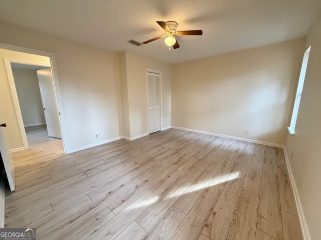 a view of empty room with wooden floor