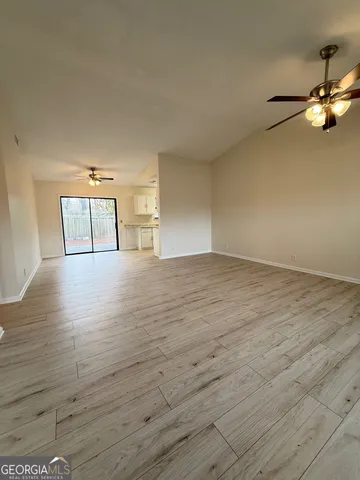 a view of empty room with wooden floor