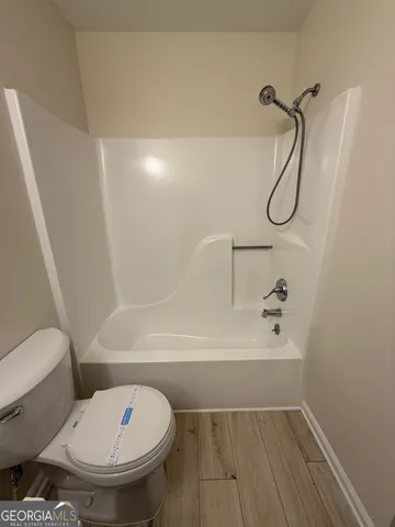 a bathroom with a toilet and a shower
