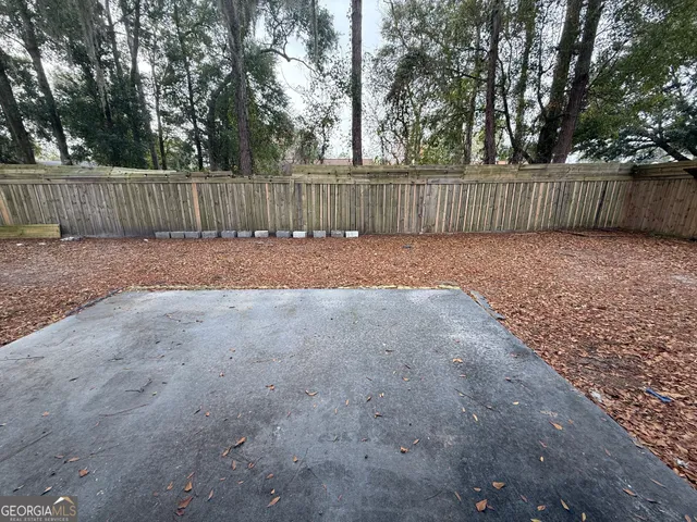 a view of a backyard with wooden fence