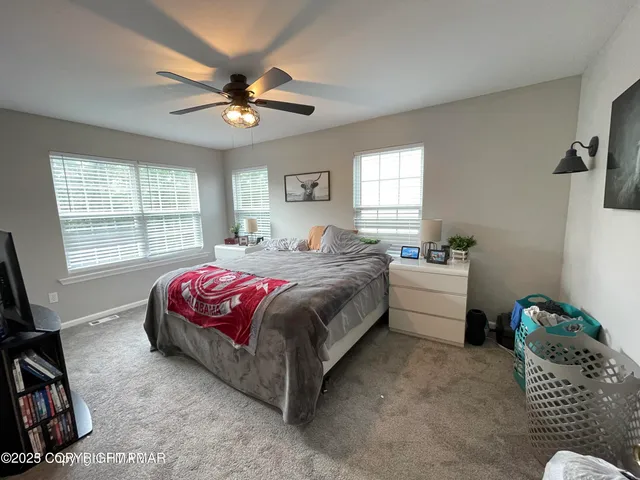 a bedroom with a bed couch and a window