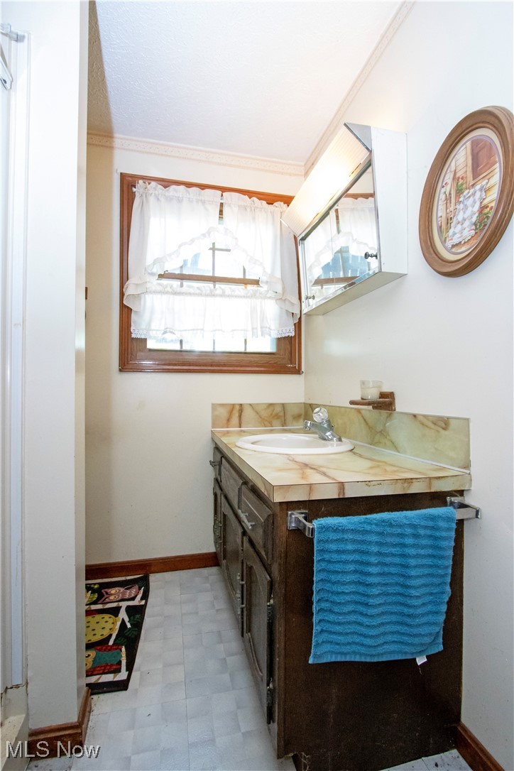 1292 Cinder Road Southeast Carrollton, OH 44615 - Photo 39 of 42 Bathroom featuring vanity, healthy amount of natural light, tile patterned floors, and ornamental molding