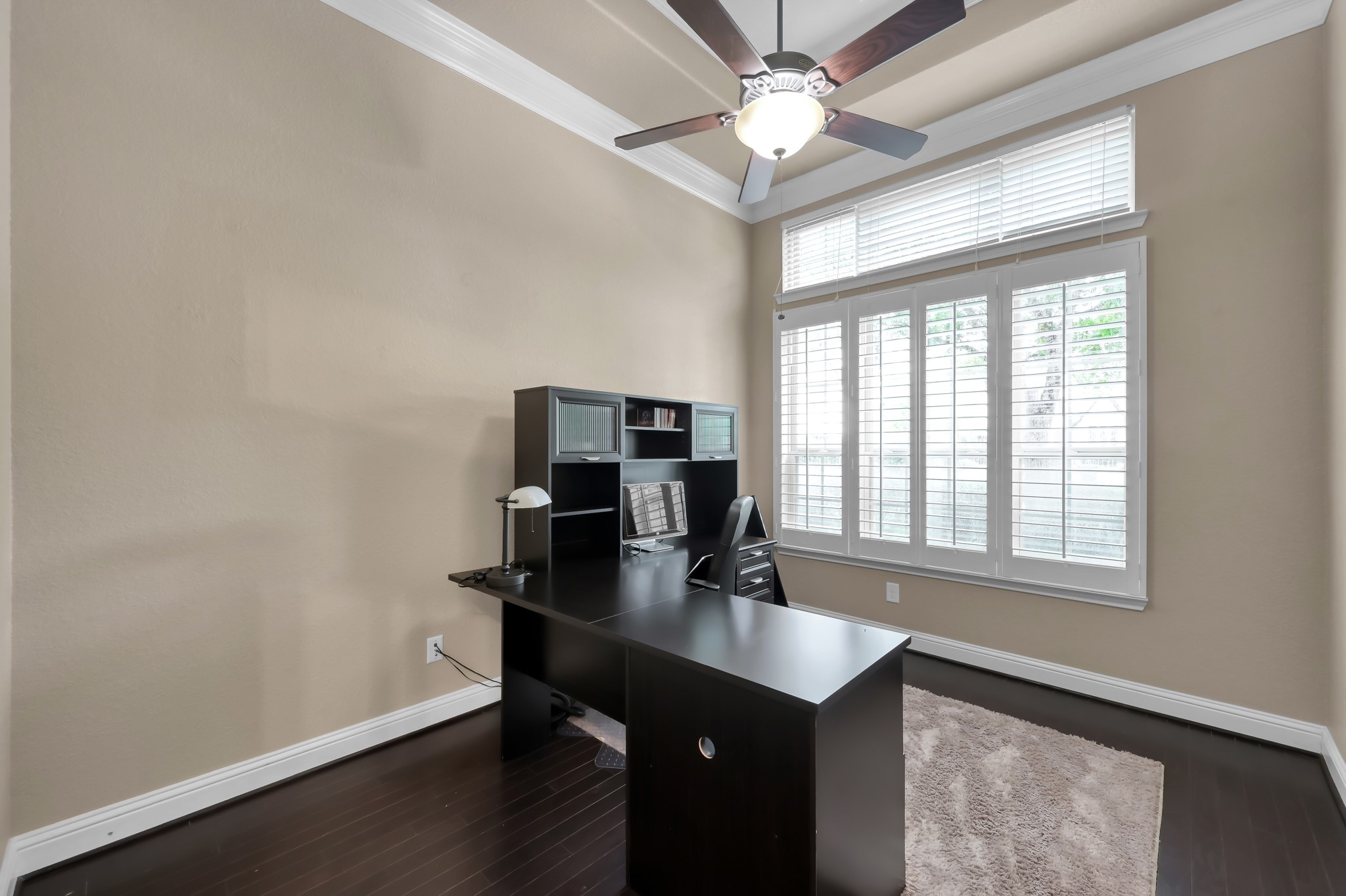 23 Rancher's Trail Tomball, TX 77375 - Photo 4 of 40 Discover the perfect home office by the entrance, featuring elegant plantation shutters, rich wood floors, and a sophisticated coffered ceiling.